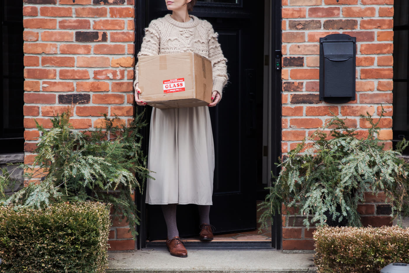 Maya at her door with the new parcel
